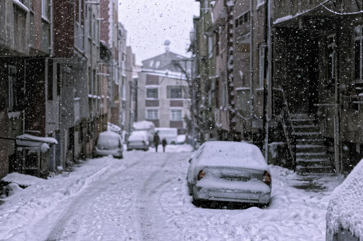 Verschneite Straße mit Autos während extremem Schneefall